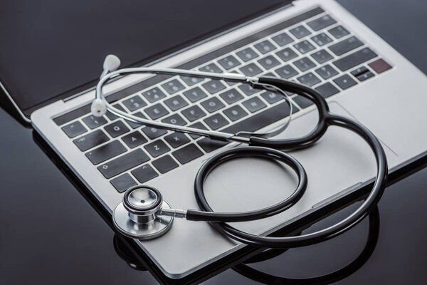 selective focus of stethoscope and laptop on glass surface 