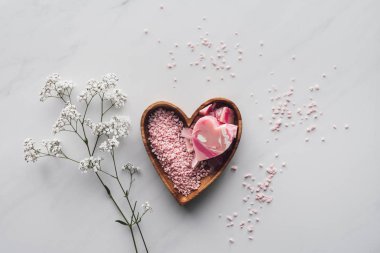 top view of pink sea salt and handmade soap in heart shaped bowl on white clipart