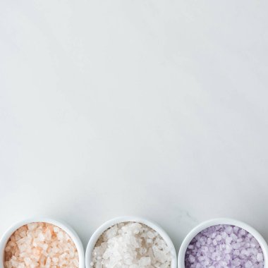 top view of colorful sea salt in bowls on white background  clipart