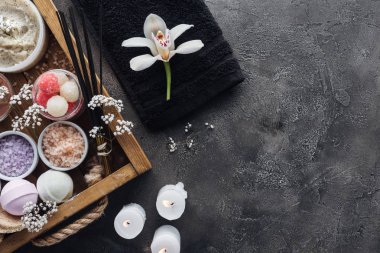 Güzel orkide, havlu, yanan mumlar ve spa aksesuarları gri arka plan üzerinde üstten görünüm