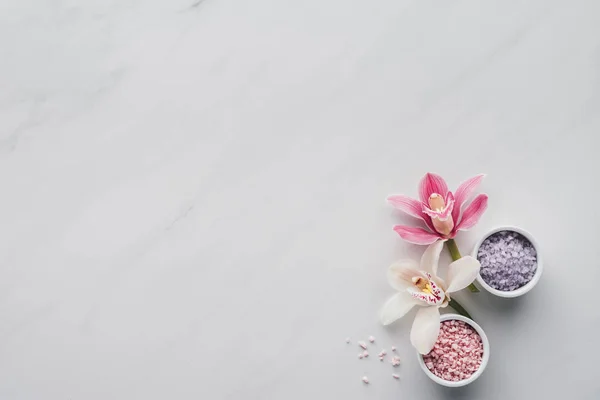 白色背景下碗中美丽的兰花花和海盐的顶部景色 — 图库照片