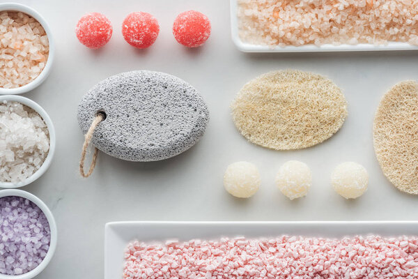 top view of various sea salt, sponges and handmade soap on white