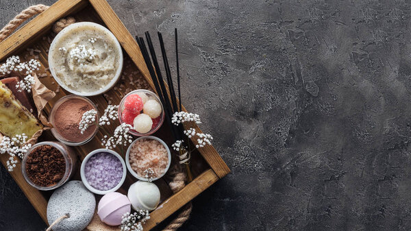 вид спа и аксессуаров для ухода за телом в деревянной коробке на сером фоне
 