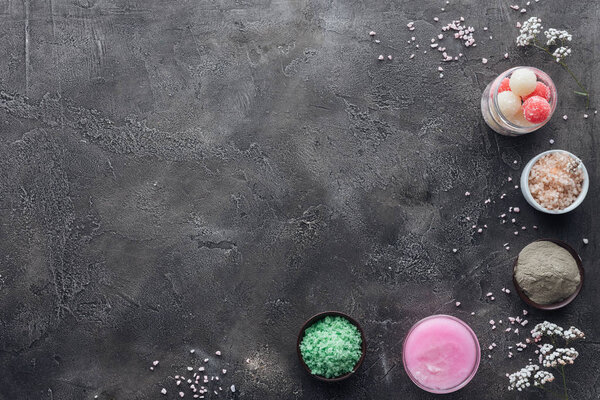 вид скраба ручной работы, сливок и морской соли на сером фоне
