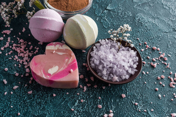 крупным планом вид фиолетовой морской соли и мыла ручной работы на сером
