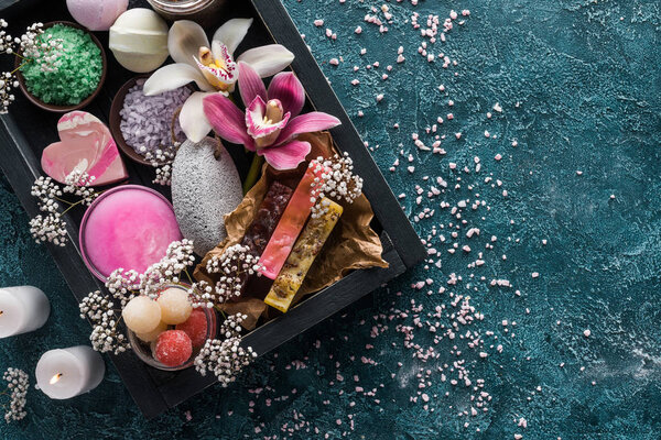 вид на горящие свечи, мыло ручной работы и органические спа аксессуары с цветами
