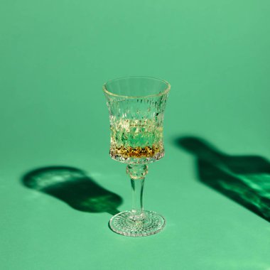close-up shot of crystal glass of absinthe on green surface clipart
