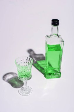 crystal glass and bottle of absinthe on white clipart
