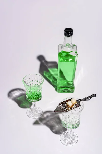 Κρυστάλλινα Ποτήρια Κουτάλα Αψέντι Και Ένα Μπουκάλι Του Αψέντι Λευκό — Δωρεάν Φωτογραφία