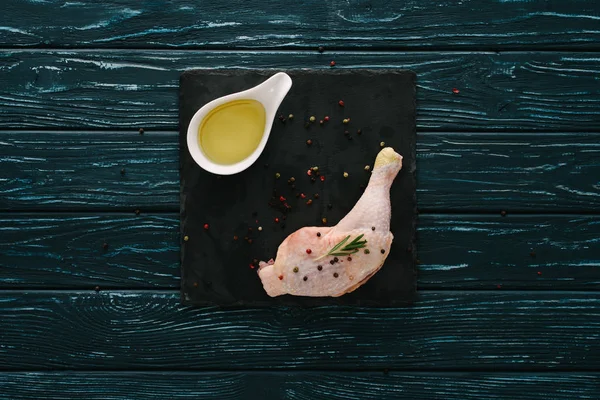 Top view of chicken leg with pepper corns and oil on stone board — Stock Image Top View Chicken Leg Pepper Corns Oil Stone Board Stock Photo