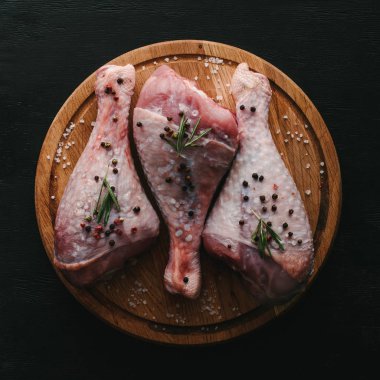 çiğ hindi budu biber Mısır ve biberiye ile üstten görünüm ahşap kesme tahtası üzerinde