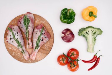 çiğ hindi budu rosemary ile üstten görünüm yakınındaki, izole üzerinde beyaz farklı sebze ile kesme tahtası üzerinde