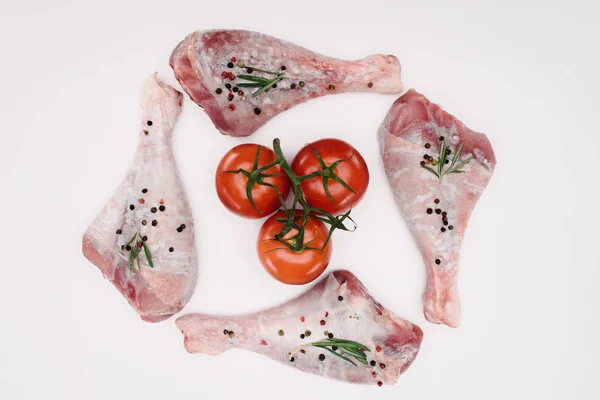 top view of chicken legs and cherry tomatoes, isolated on white