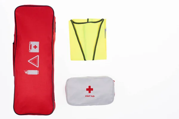 flat lay with automotive handbag, first aid kit and reflective vest isolated on white