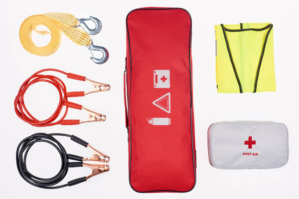 top view of red handbag with arranged automotive accessories around isolated on white