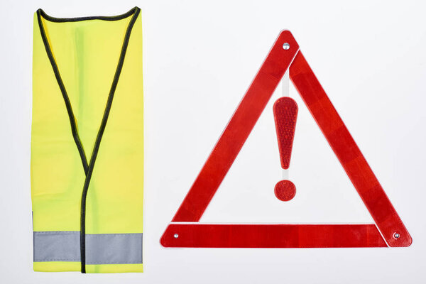 top view of warning triangle and reflective vest isolated on white