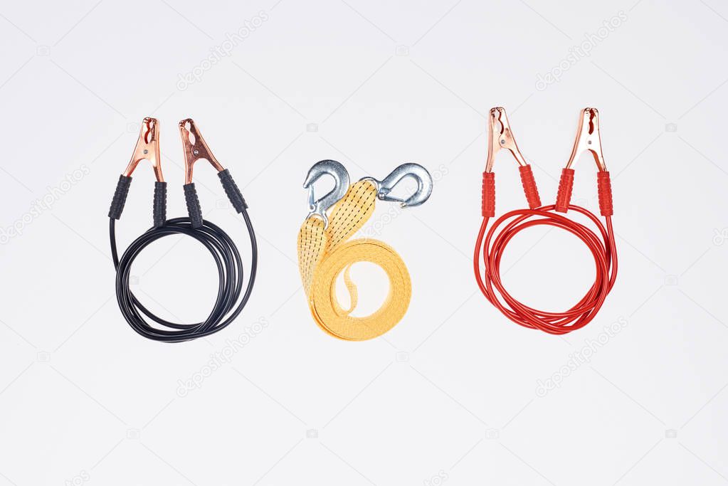 flat lay with arranged car tow rope and jump start cables isolated on white
