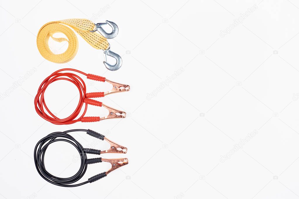 top view of arranged car tow rope and jump start cables isolated on white