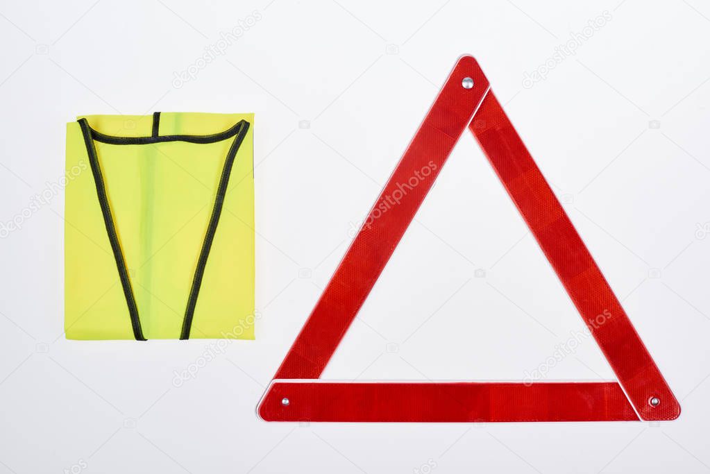 top view of warning triangle and reflective vest isolated on white