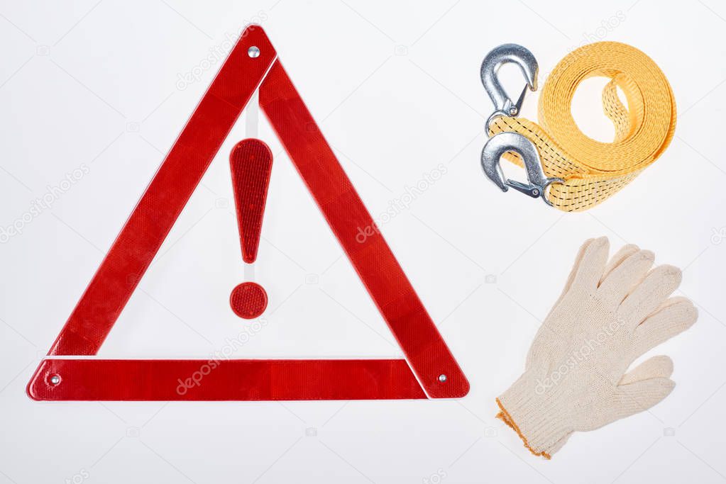 flat lay with warning triangle, gloves and car tow rope isolated on white