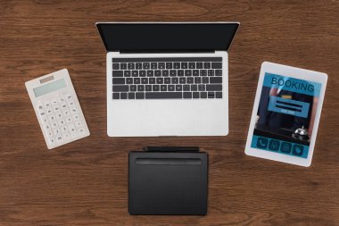 boş ekran, hesap makinesi, ders kitabı ve ekranda rezervasyon ile dijital tablet ile dizüstü üstten görünüm 