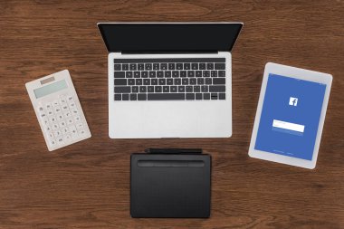 Ekranda boş ekran, hesap makinesi, ders kitabı ve facebook ile dijital tablet ile dizüstü üstten görünüm 
