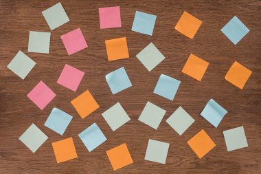 top view of arranged colorful post it notes on wooden table  clipart