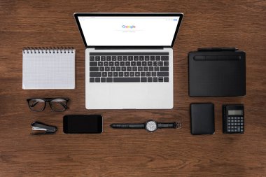 çalışma alanı görücü usulü boş ders kitabı, smartphone, kol saati ve google ile dizüstü bilgisayar ile ekranda yukarıdan
