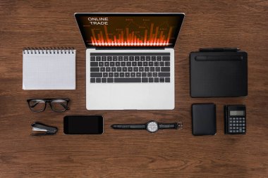 çalışma alanı görücü usulü boş ders kitabı, smartphone, kol saati ve online ticaret ile dizüstü bilgisayar ile ekranda yukarıdan