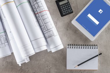 mimar çalışma alanı boş ders kitabı, hesap makinesi ve facebook ile dijital tablet ile ekranda yukarıdan 
