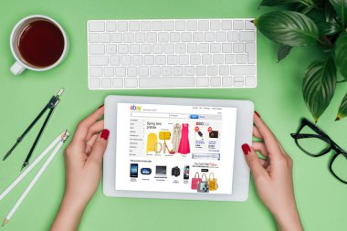 kadın mimar masada bölücü, kahve ve Saksı bitki ile ekranda dijital tablet ebay ile tutarak resim kırpılmış 