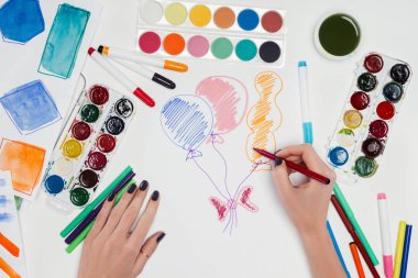 cropped image of female artist drawing air balloons at white table with colorful paints  clipart