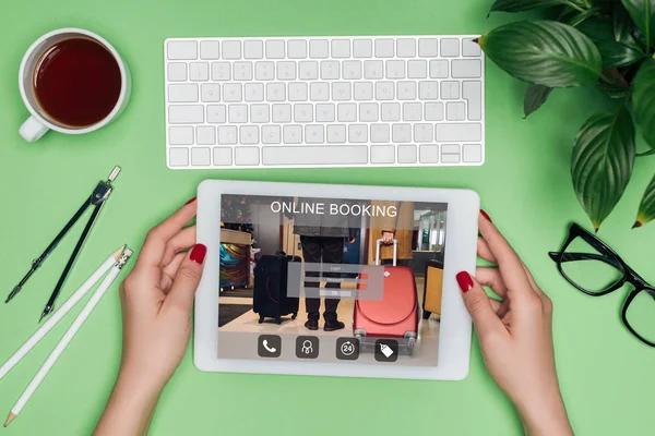 分周器 コーヒー 鉢植えの植物とのテーブルで画面にオンライン予約デジタル タブレットを保持している女性の建築家のイメージをトリミング  — 無料ストックフォト