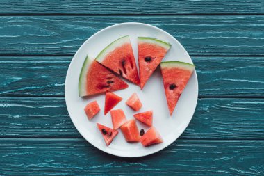 mavi ahşap masa üzerinde plaka üzerinde suyu karpuz adet düzenlemenin üstten görünüm