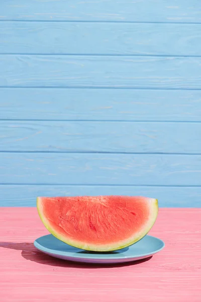 Nahaufnahme Der Frischen Wassermelonenscheibe Auf Rosa Tischplatte Vor Blauem Hintergrund — Stockfoto