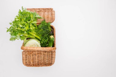 top view of raw autumn vegetables in basket isolated on white clipart