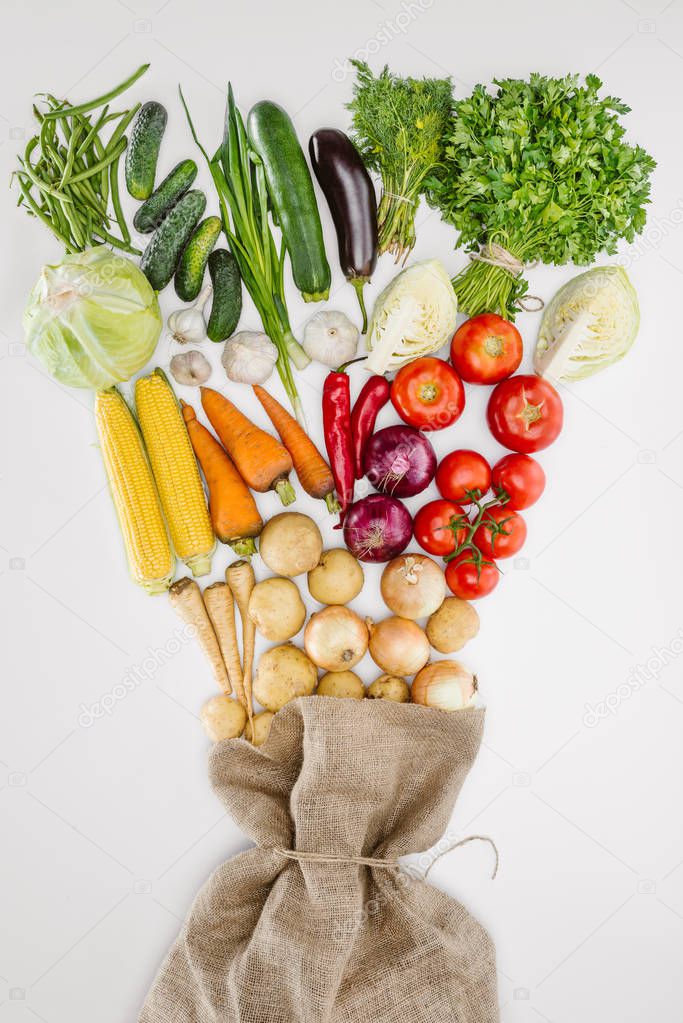 top view of fresh raw vegetables and sackcloth arranged isolated on whit