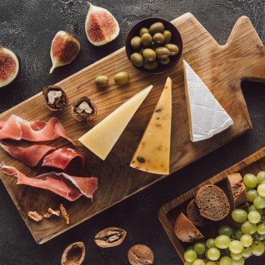 düz lay çeşitli peynir, jamon ve meyve karanlık yüzeyi ile