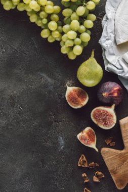 Düzenlenmiş incir, üzüm ve peynir karanlık yüzeyi düz lay