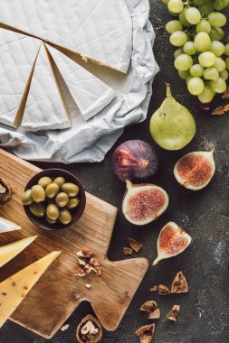 karanlık masa üzerinde çeşitli peynir, zeytin kase ve meyve üstten görünüm