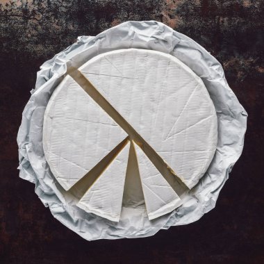 karanlık yüzey üzerinde kesme camembert peyniri üstten görünüm