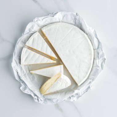 top view of camembert cheese on white marble tabletop clipart