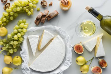 food composition with brie cheese, wine, grape and bread on white marble surface clipart