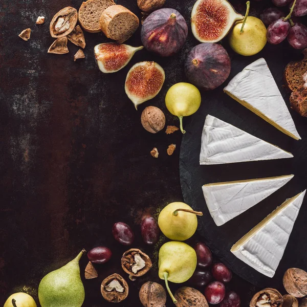 Ovanifrån Camembert Ost Bitar Och Frukter Arrangerade Mörk Yta — Stockfoto