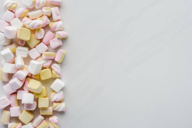 top view of yummy colored marshmallows on white surface clipart