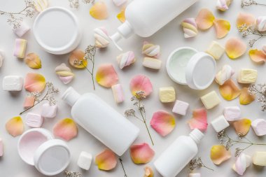 şişe krem, gül yaprakları ve Marshmallow üstten görünüm beyaz masa üstü, güzellik kavramı