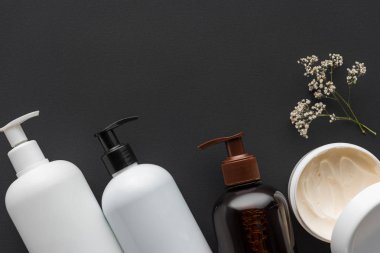 siyah, güzellik kavramı izole krem ve kurutulmuş çiçeklerin şişe üstten görünüm