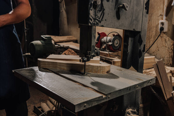 partial view of woodworker at wooden workshop
