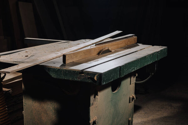 close up view of circular saw and materials at wooden workshop