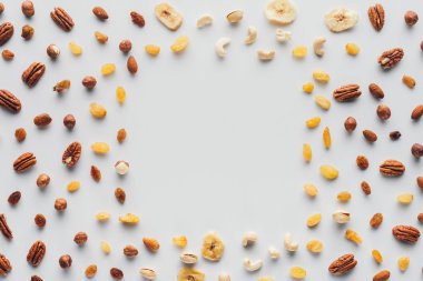 top view of dried fruits and nuts with copy space in center isolated on white background clipart